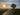 Sunrise over a misty rural landscape with a tree and path.